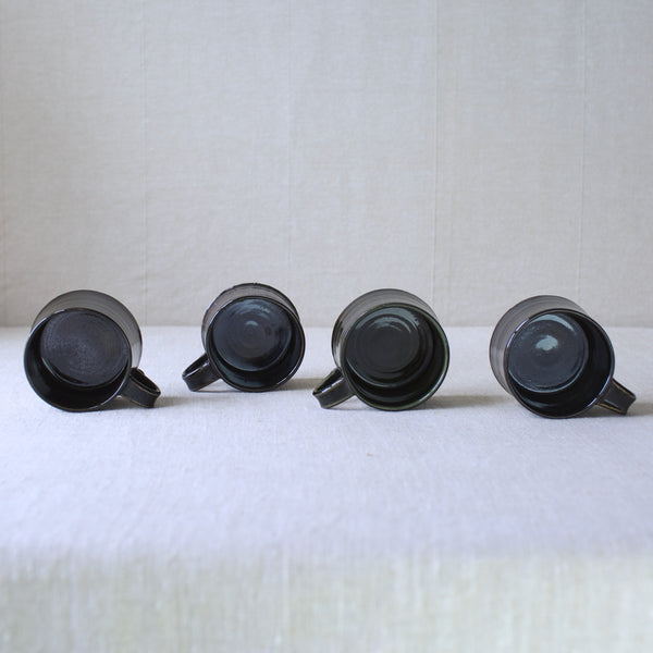 Shot showing the interiors of a set of four hand-thrown stoneware cups by Kaarina Aho for Arabia, Finland. A fine example of Finnish modernist design, now available for sale.