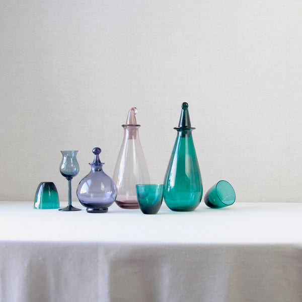 Riihimaki glass collection of decanters and drinking glasses by nanny Still and Tamara Aladin, including 'SV' in pink and turquoise, Tamara Aladin's first design for Riihimaki, and a rare lilac vinegar bottle. 