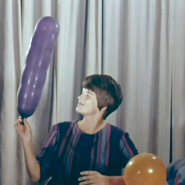 Film still of Finnish designer, Nanny Still, in 1960. She is holding a long party balloon, perhaps the inspiration for her 'Carnevaali' series.