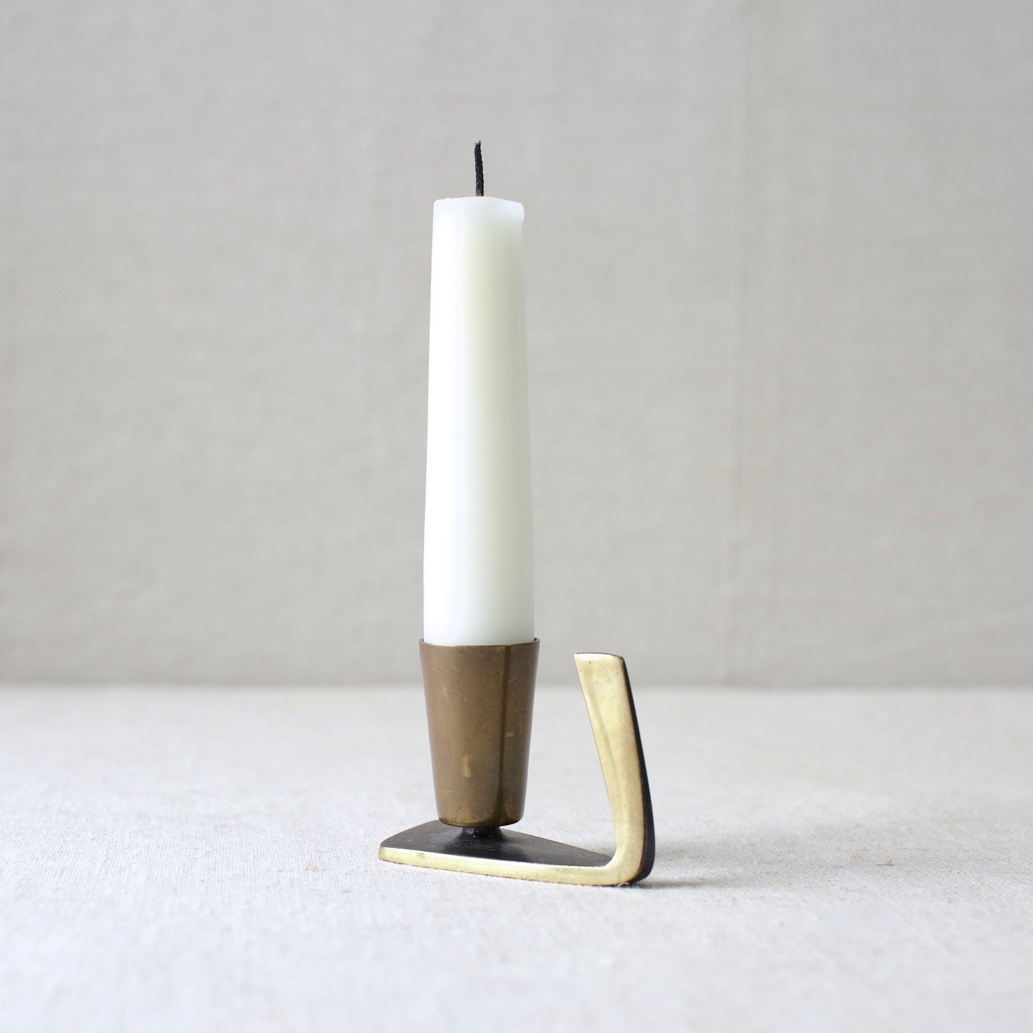 A rare Karl Hagenauer brass candle holder from the 1950s. This sleek, Art Deco-inspired Modernist design was crafted in Vienna and showcases the renowned Viennese metalwork tradition. A collectible mid-century piece.