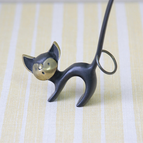 This cute 1950s Walter Bosse brass cat pretzel holder is a true Modernist collectible. Made in Vienna, it brings a touch of mid-century charm to any display.