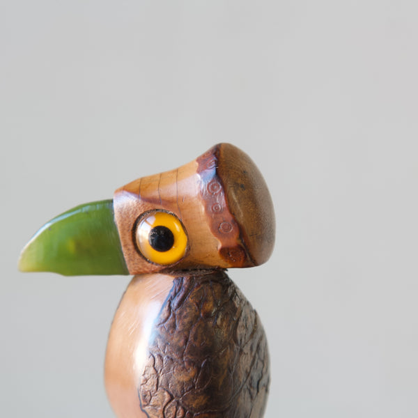 Henry Howell YZ bird nut and bakelite bottle stopper, a detail shot showing impressed tooled decoration around the face