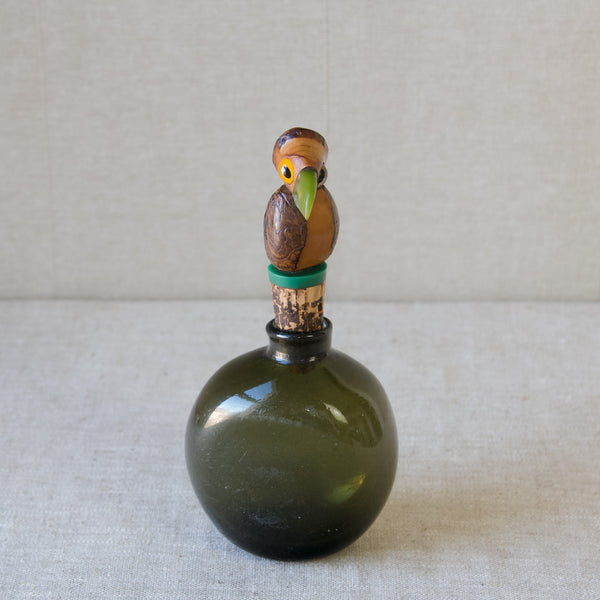 An original Art Deco 1920s Henry Howell YZ nut bird bottle stopper with cork and bakelite beak, sitting in an antique green glass bottle, London.