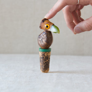 A finger supporting a 1920's Art Deco bakelite tagua nut bird YZ bottle stopper by Henry Howell. The hand is wearing a Seb Brown silver ring. 
