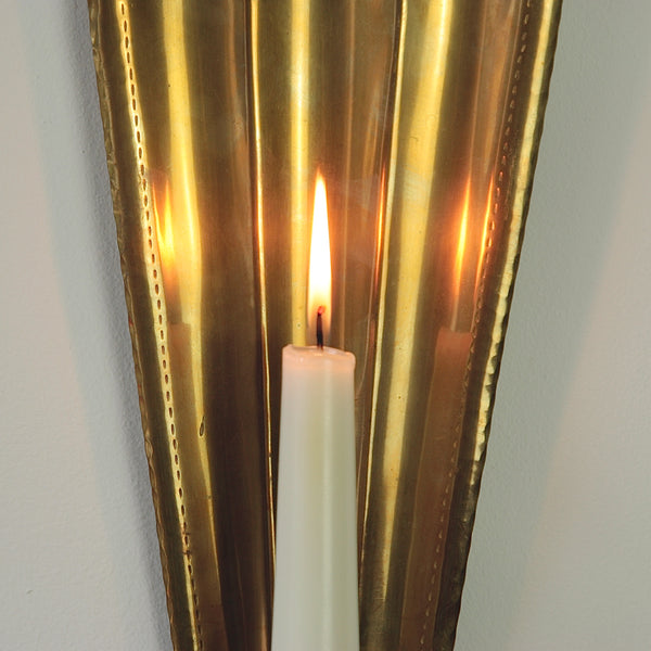 Close up of a Carl Malmstedt designed and made handcrafted brass wall sconce. The design reflects light beautifully.