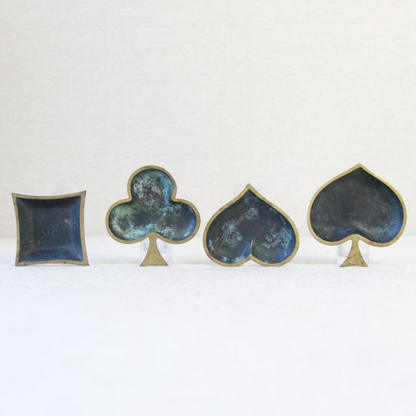 Rare collection of modernist brass ashtrays, each shaped like a playing card suit, representing mid-20th-century European metalware craftsmanship.