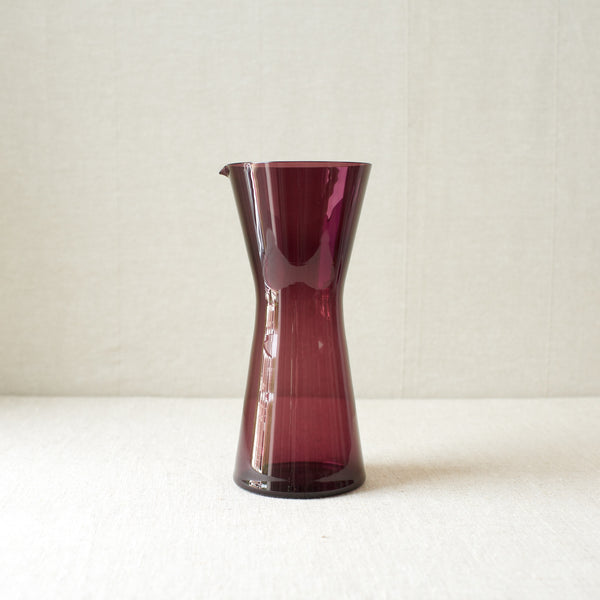 A vibrant lilac purple cocktail pitcher designed by Kaj Franck in 1954, hand-blown at Nuutajärvi Notsjö, Finland. Mid-century modern design with geometric form.