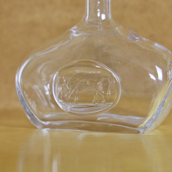 Close up of the walking bull pressed into the circular seal applied to erik hoglund bottle made by Boda Sweden circa 1960