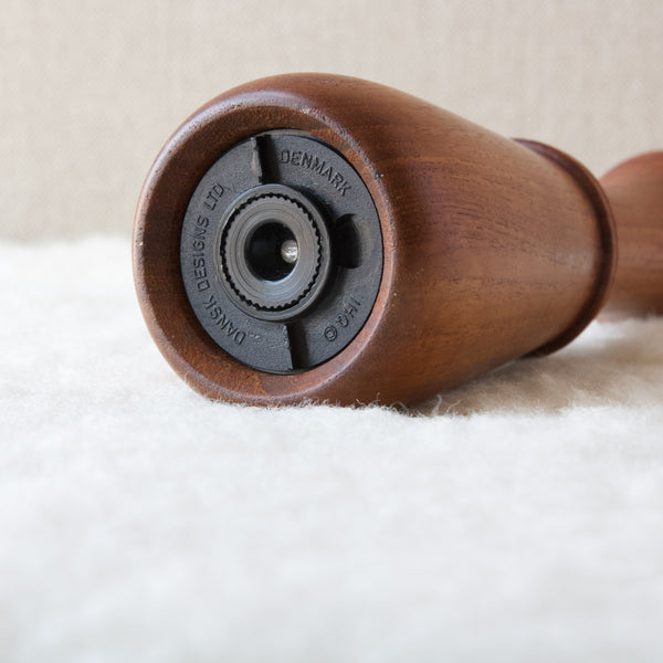 Detail shot showing the underside of a teak peppermill designed by Jens Quistgaard, makers mark reads Dansk Designs Ltd Denmark IHQ copyright. This Danish design and many other available to buy online at Art and Utility, London.