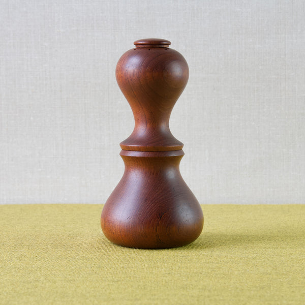 A curvaceous hourglass shaped pepper mill carved from solid teak. Design by Jens Quistgaard for Dansk Designs. This example made in Denmark in the 1960s or 70s.
