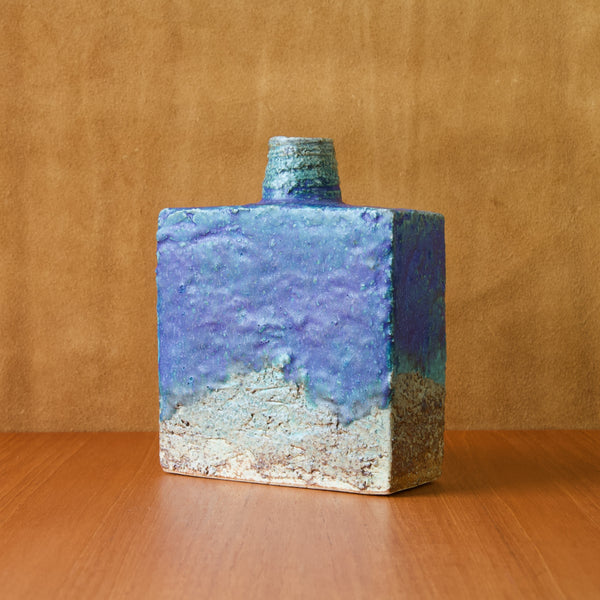 Mood image showing an Annikki Hovisaari vase stood at an angle in natural daylight. The image highlights how the blue cobalt glaze is not entirely shiny or complete mat.