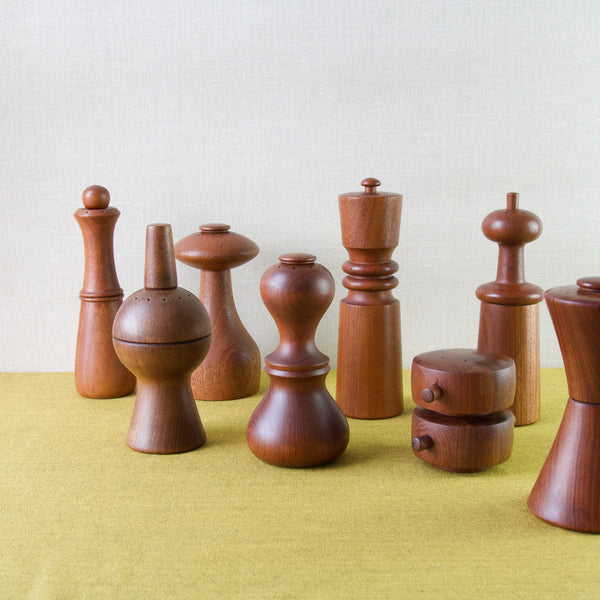 A group shot of eight different Jens Quistgaard pepper mills in teak produced by Dansk Design Ltd. All items photographed and lots of other collectable Nordic designs are available to buy from Art & Utility, London.