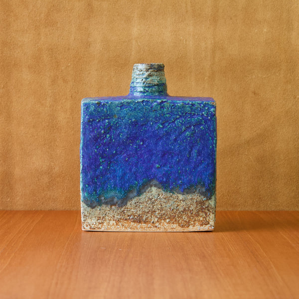 Straight on image showing a large square ceramic bottle vase by Finnish ceramicist Annikki Hovisaari. The vase features an exceptionally deep cobalt blue glaze typical of her bold work.