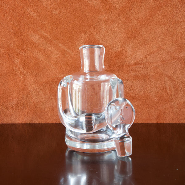 A clear glass person decanter designed by Erik Höglund with face-shaped stopper and applied arms