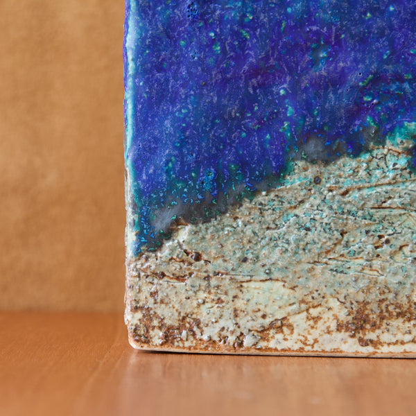 Close up showing the corner of a square shaped vase by Annikki Hovisaari the picture shows how the cobalt blue glaze does not cover the entirety of the heavily textured chamotte clay.