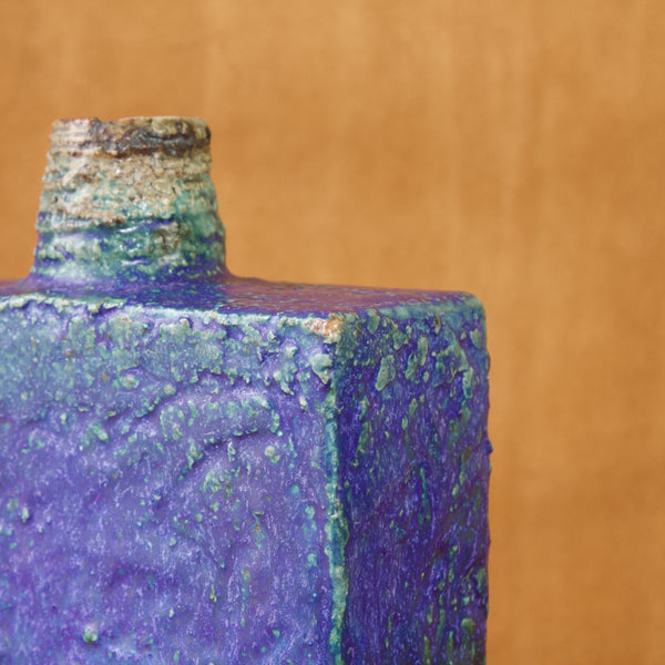 Detail showing the corner of a square shouldered vase. Where the point is most extreme the beige brown clay underneath breaks through the cobalt blue glaze. This is NOT damage.