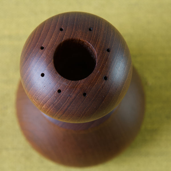 Image of a Jens Quistgaard hourglass shaped pepper mill with its large salt plug stopper removed. In the photo you can see the eight holes from which salt can be shook out.