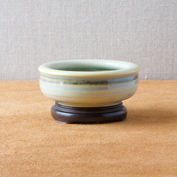 Mid century Scandinavian celadon bowl by Olle Alberius, displayed on a chinese wooden stand