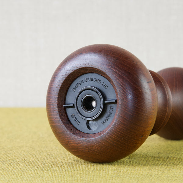Detail showing the underside of a Jens Quistgaard pepper mill. The collectable Scandinavian design is branded with the following text: DENMARK IHQ (copyrighted) DANSK DESIGNED LTD. 