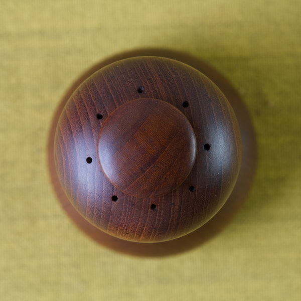 Aerial shot of a Jens Quistgaard pepper mill. This design, often reffered to as the curved hourglass with double lip, has an uncommonly large plug or stopper to hold in the salt. Produced in Denmark in the 1960s or 70s. 