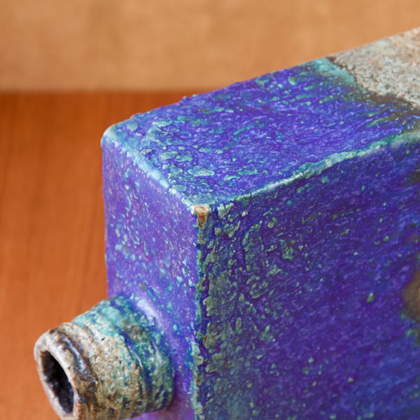 Detail of the corner of a pullo maljakko or bottle vase designed by  Annikki Hovisaari. The clay breaks through the blue glaze on the corner.